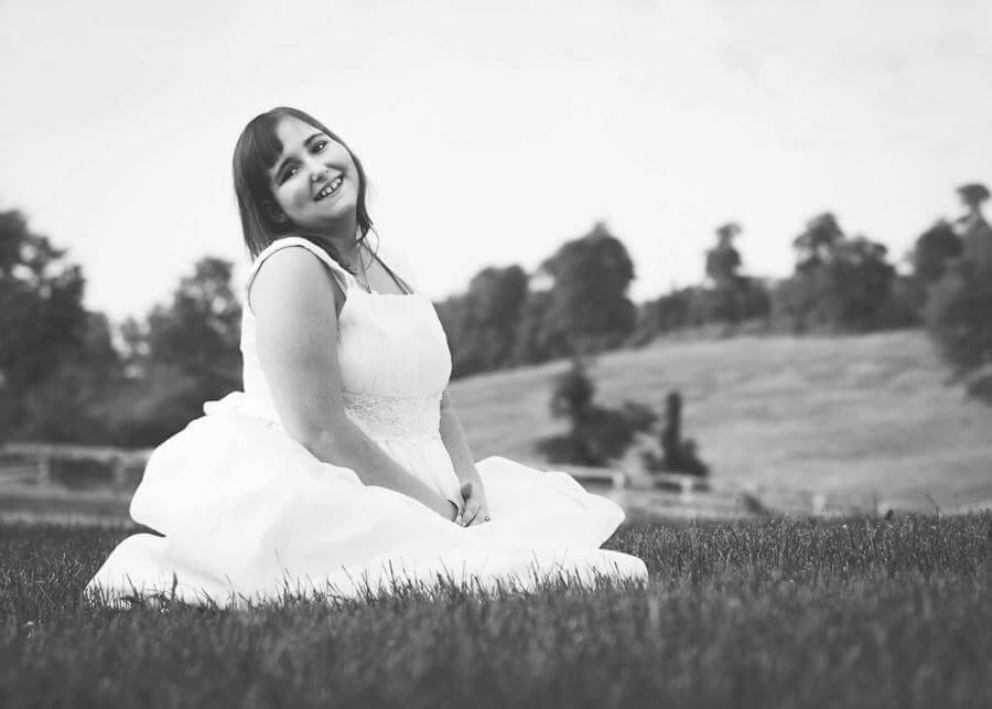 makayla sitting in field smiling